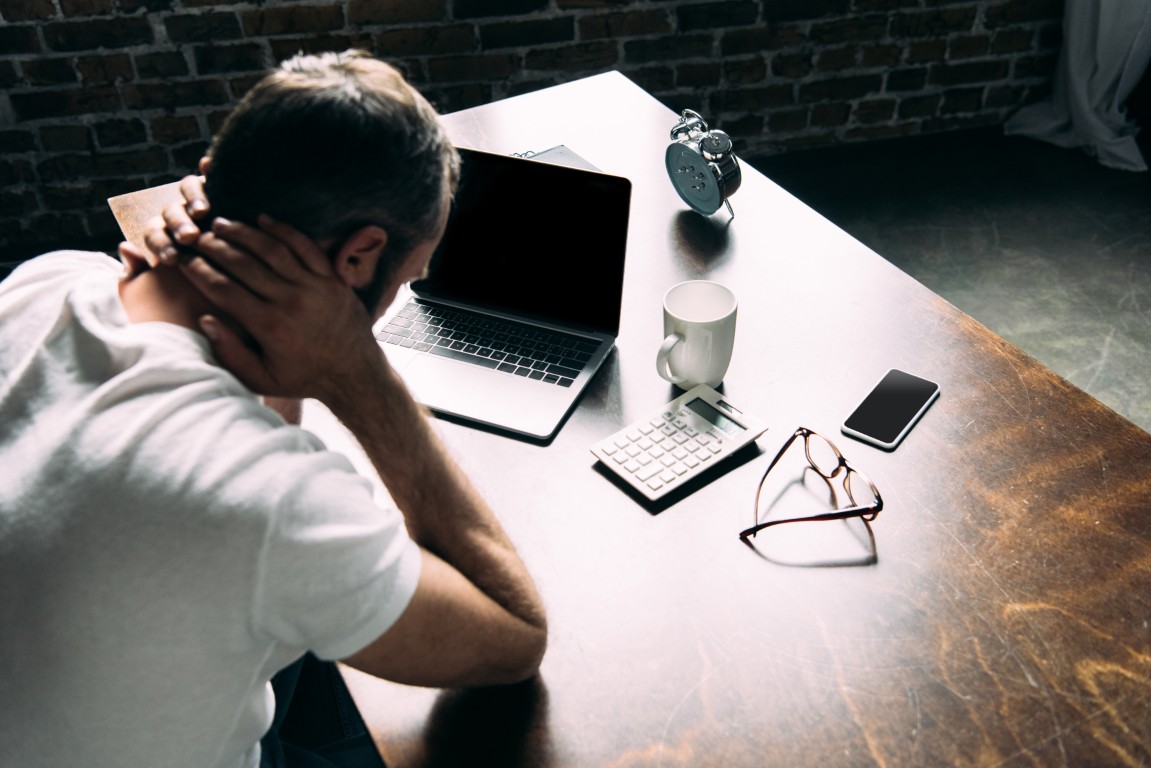 Man experiencing head pain at a desk